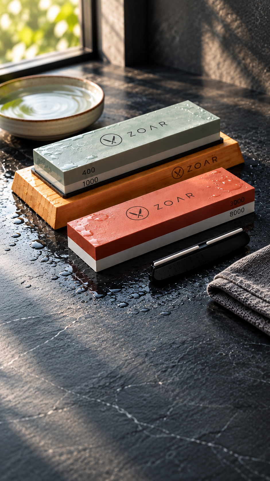 Zoar dual-grit whetstones on a bamboo base on wet slate in morning light
