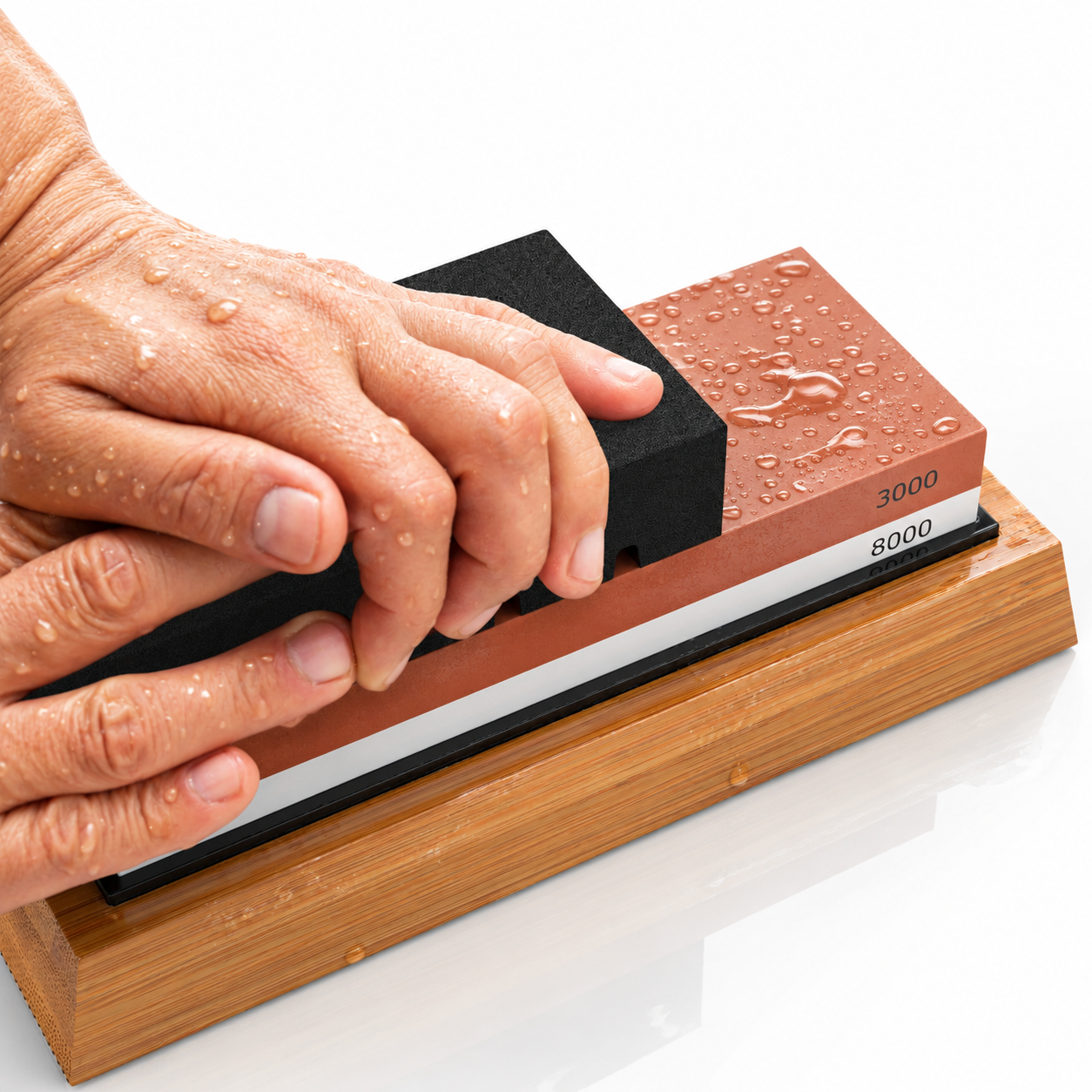 A wet dual-grit Zoar whetstone in its bamboo base with a bowl of water and the angle guide clipped to a knife
